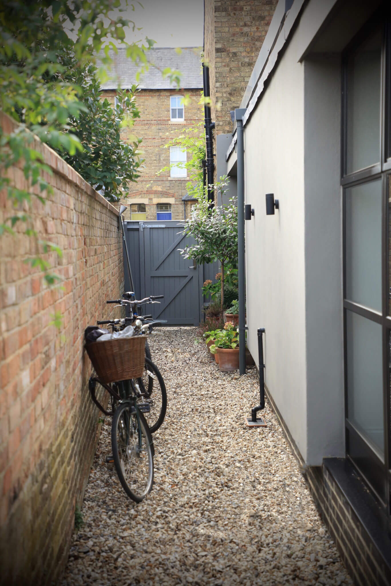 Old fashioned bike leaning against brick wall with garden gate