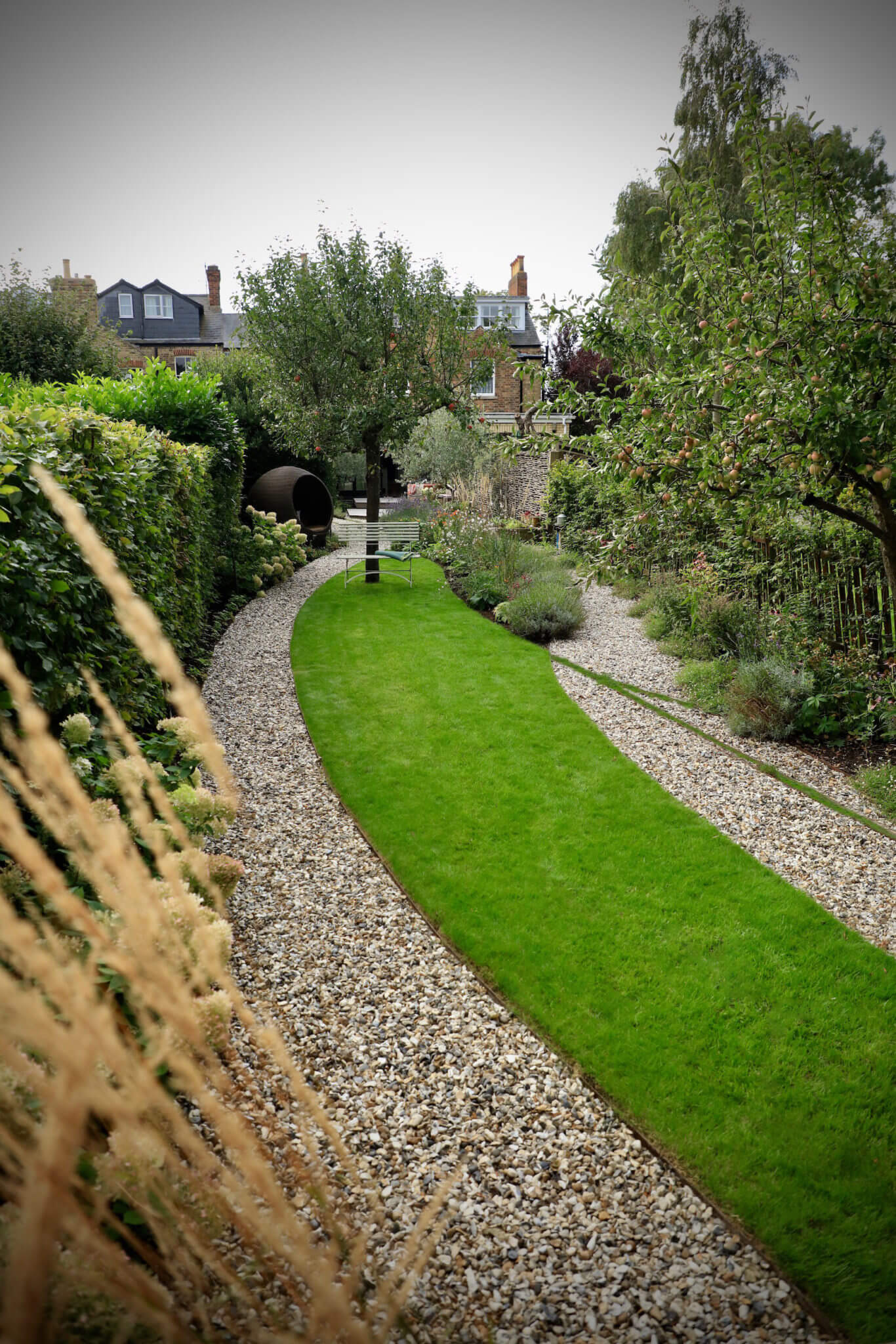 A overhead shot of a narrow green lawn with paths running eitherside