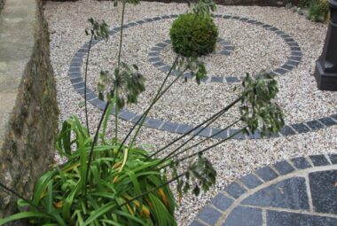 Snail pattern made from paving slabs in small garden