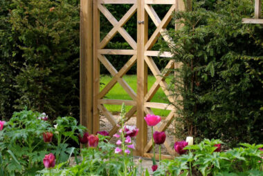 Cottage garden style planting in front of bespoke wooden gate