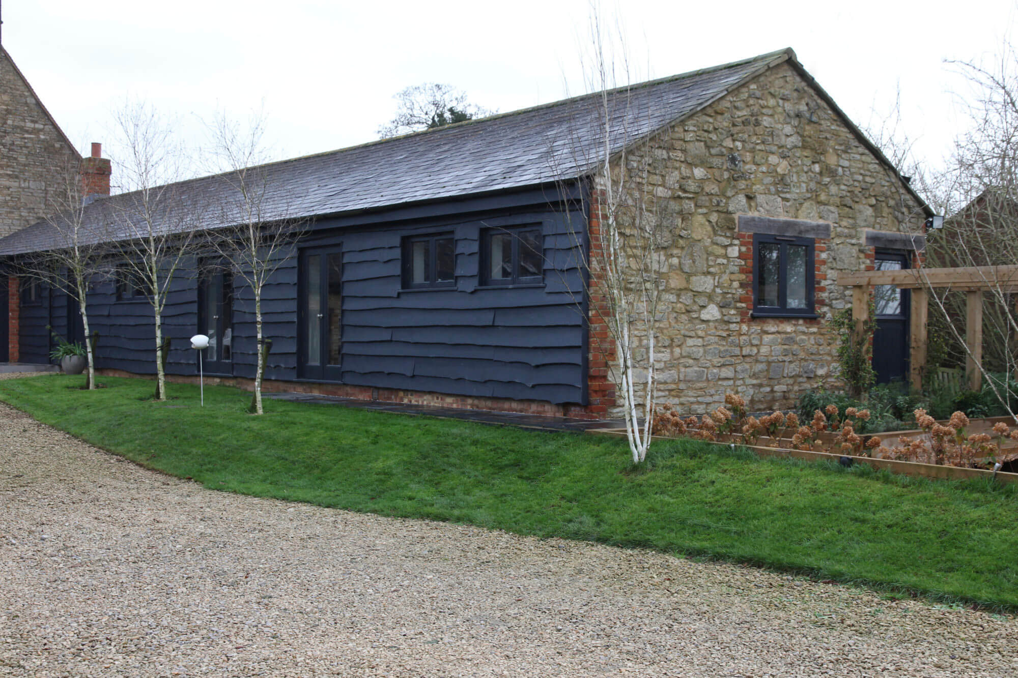 barn conversion property garden in winter with white Birch trees