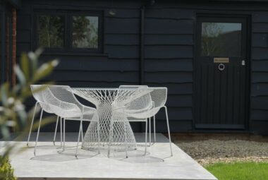 cowshed barn conversion garden with white garden furniture and concrete patio