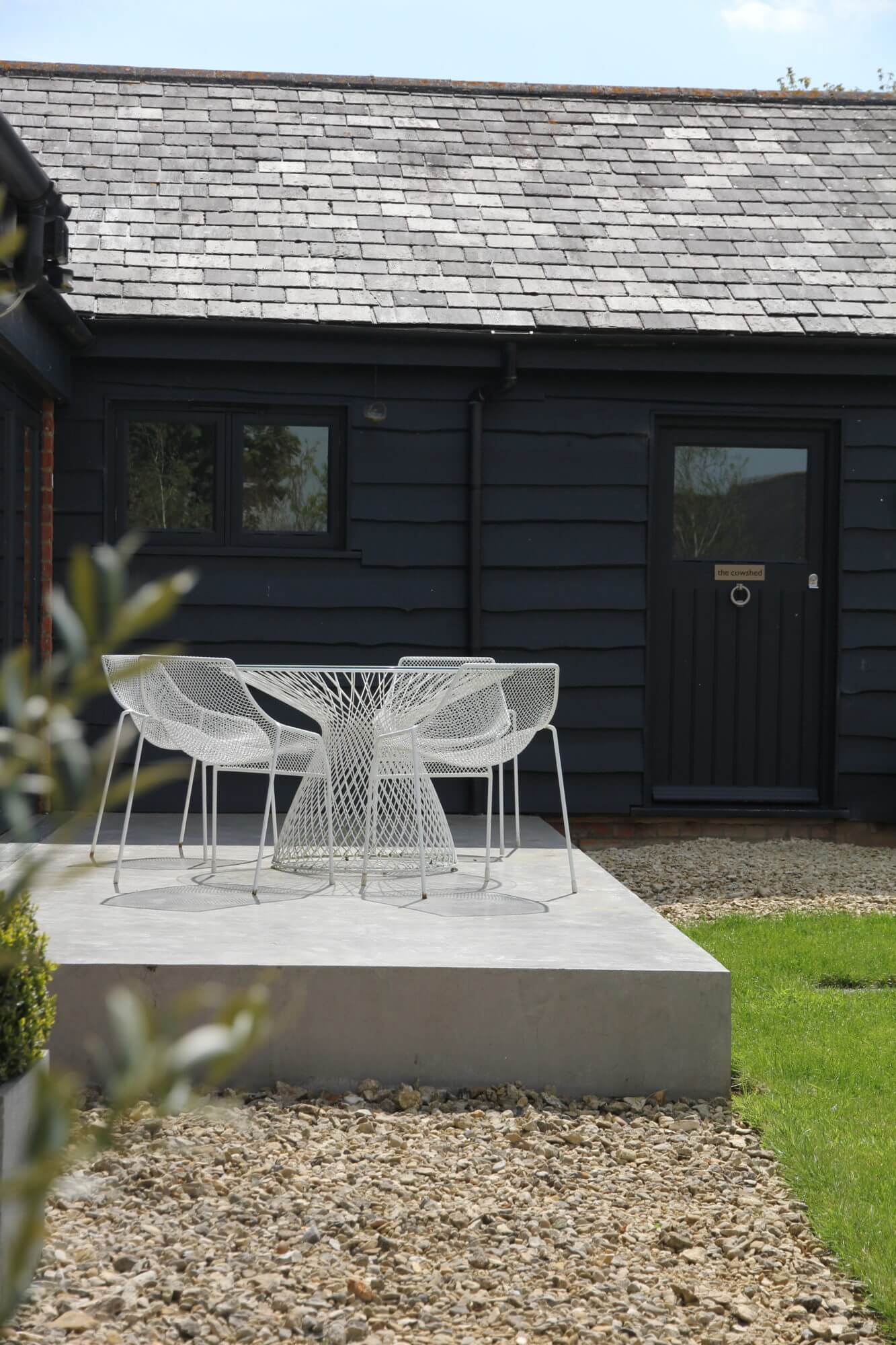 cowshed barn conversion garden with white garden furniture and concrete patio