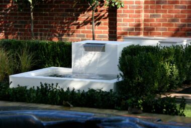 Marble garden water feature in front of red brick wall