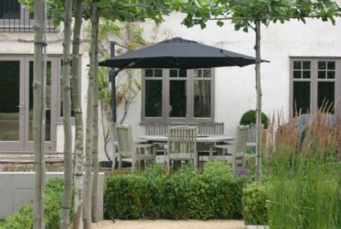 Cotswolds style farmhouse with pleached trees and pathway