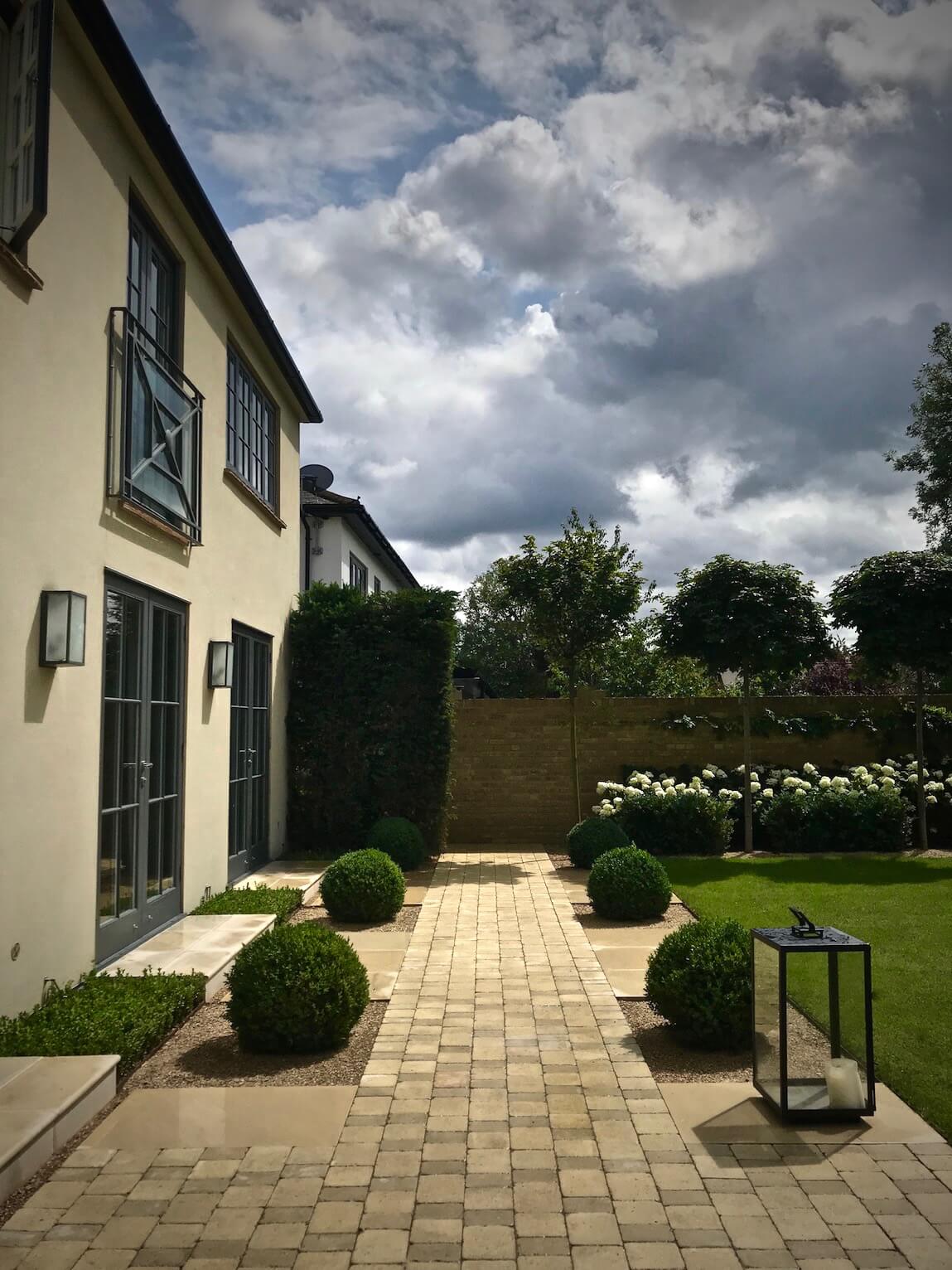 townhouse garden in Oxford cobbled path and buxom balls on a sunny day