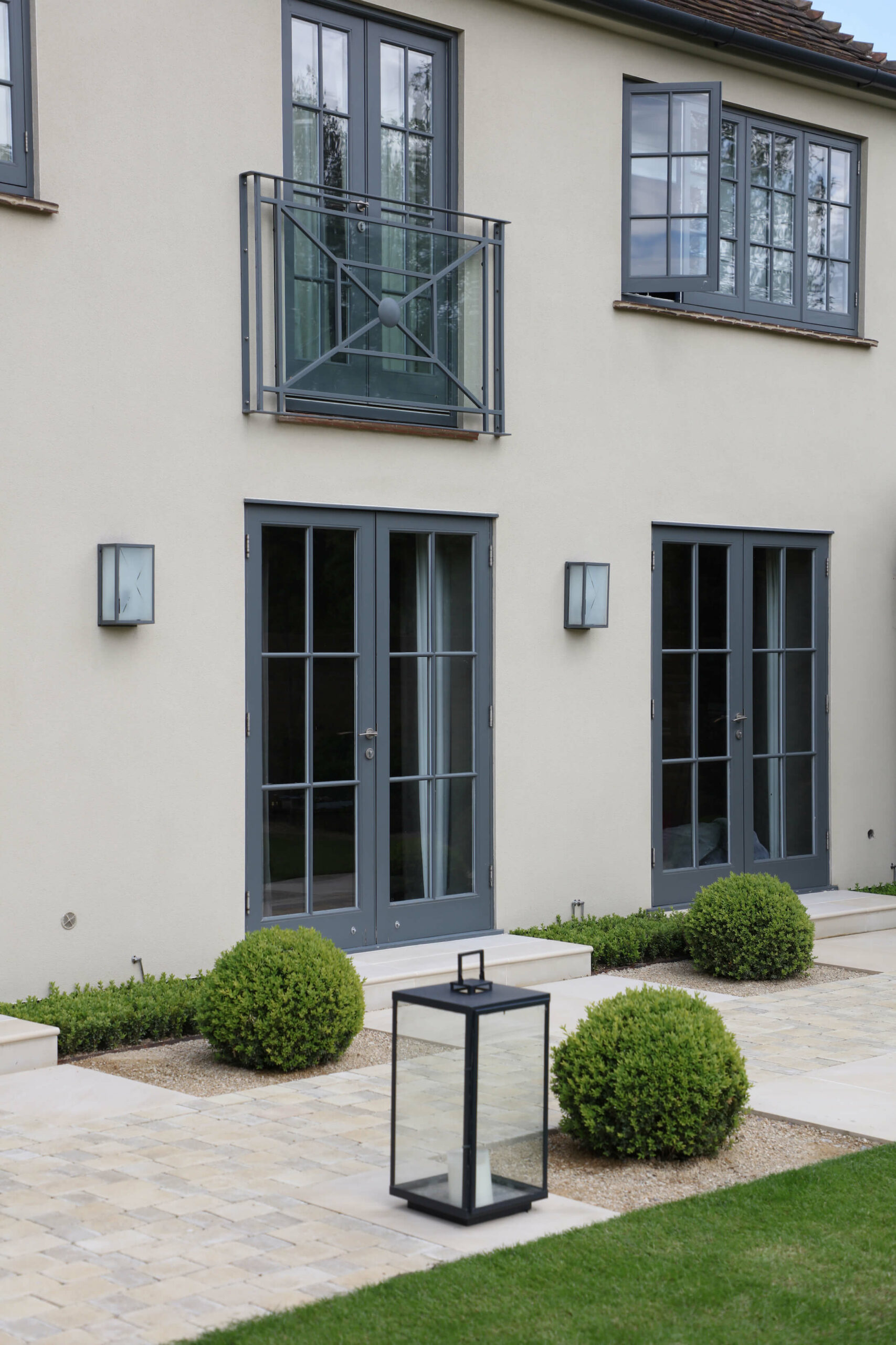 townhouse garden in Oxford with lanterns, lawn and box balls in patio