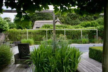 Cotswolds garden with swimming pool and thatched roof