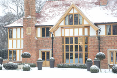 arts and crafts house covered in snow with chandelier interior