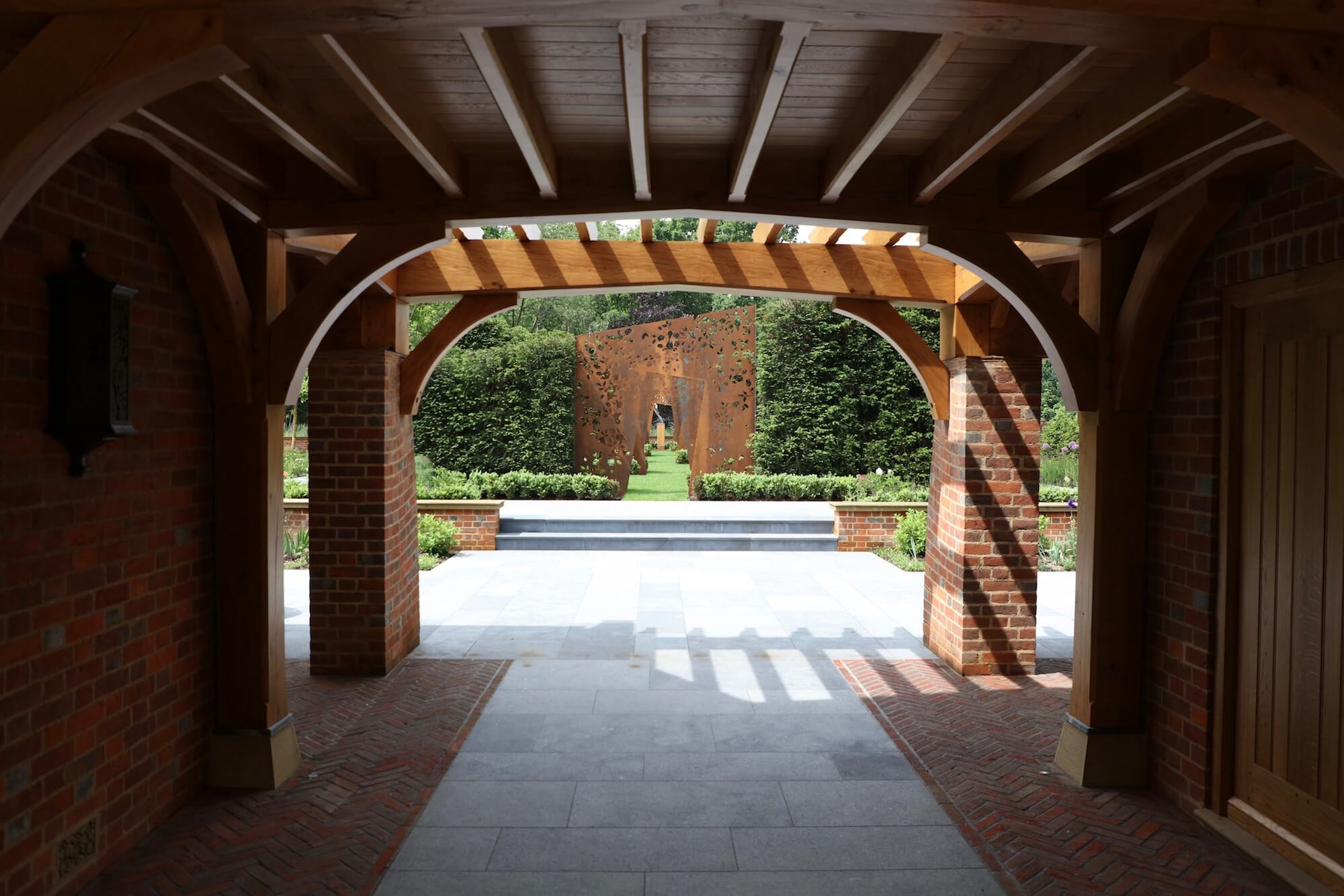 Arts & Crafts house exterior oak carved ornate archways leading to cortex laser cut rose pantry doorways