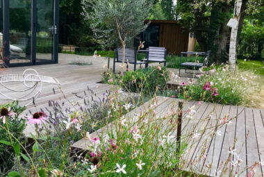 music studio in garden lakeside decked with colourful planting