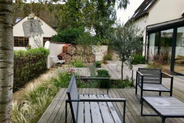 lakeside decked garden with furniture and log stores