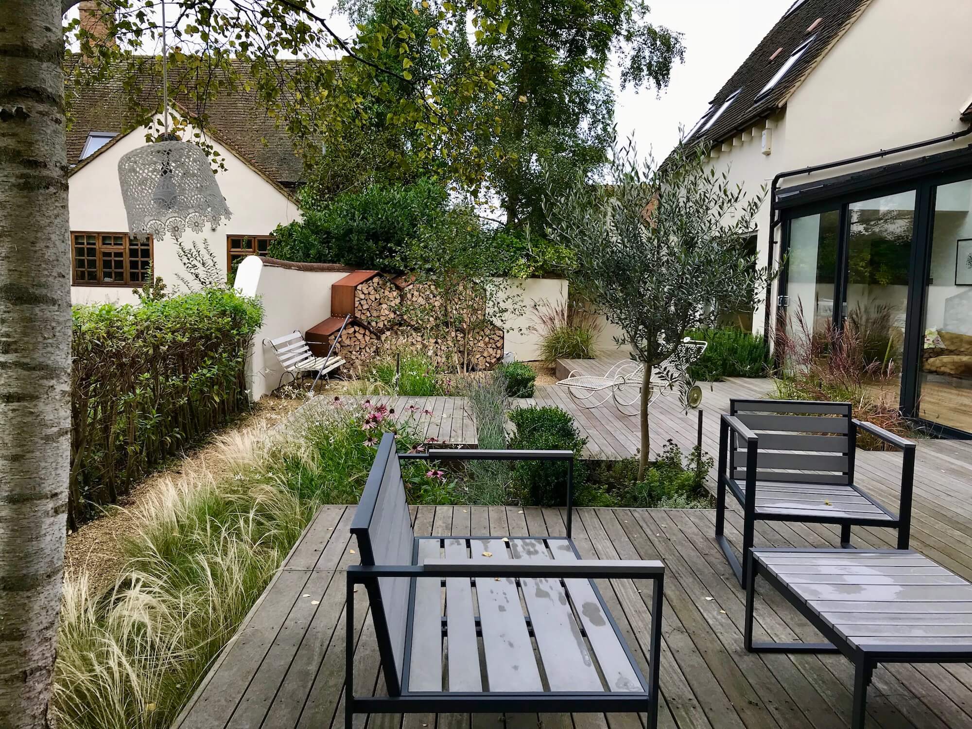 lakeside decked garden with furniture and log stores