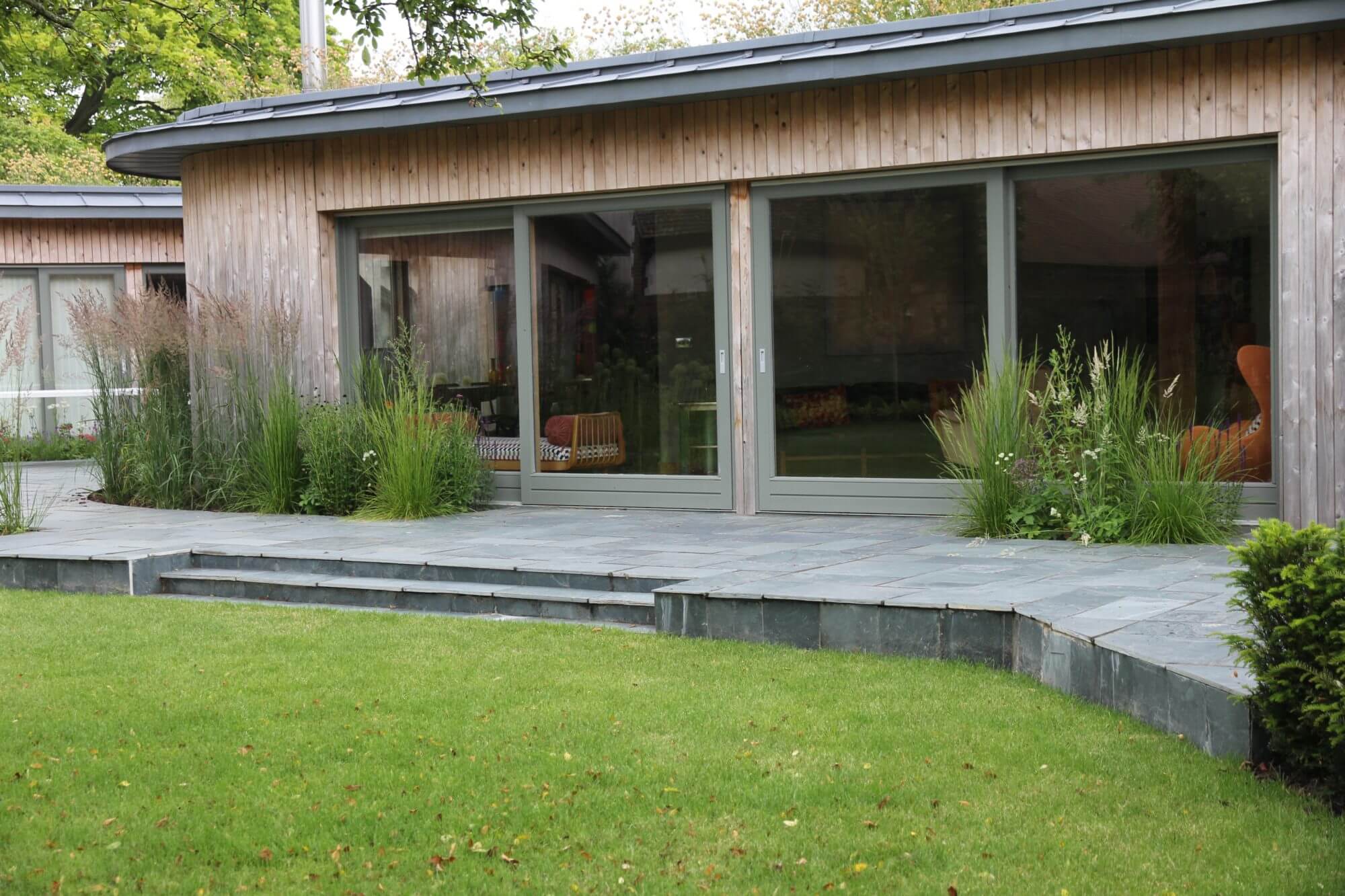 Garden studio with grey wooden decking and green lawn