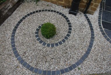 Tiled snail swirl in garden with topiary ball in the middle