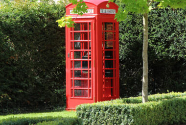 Traditional telephone box in driveway of british garden