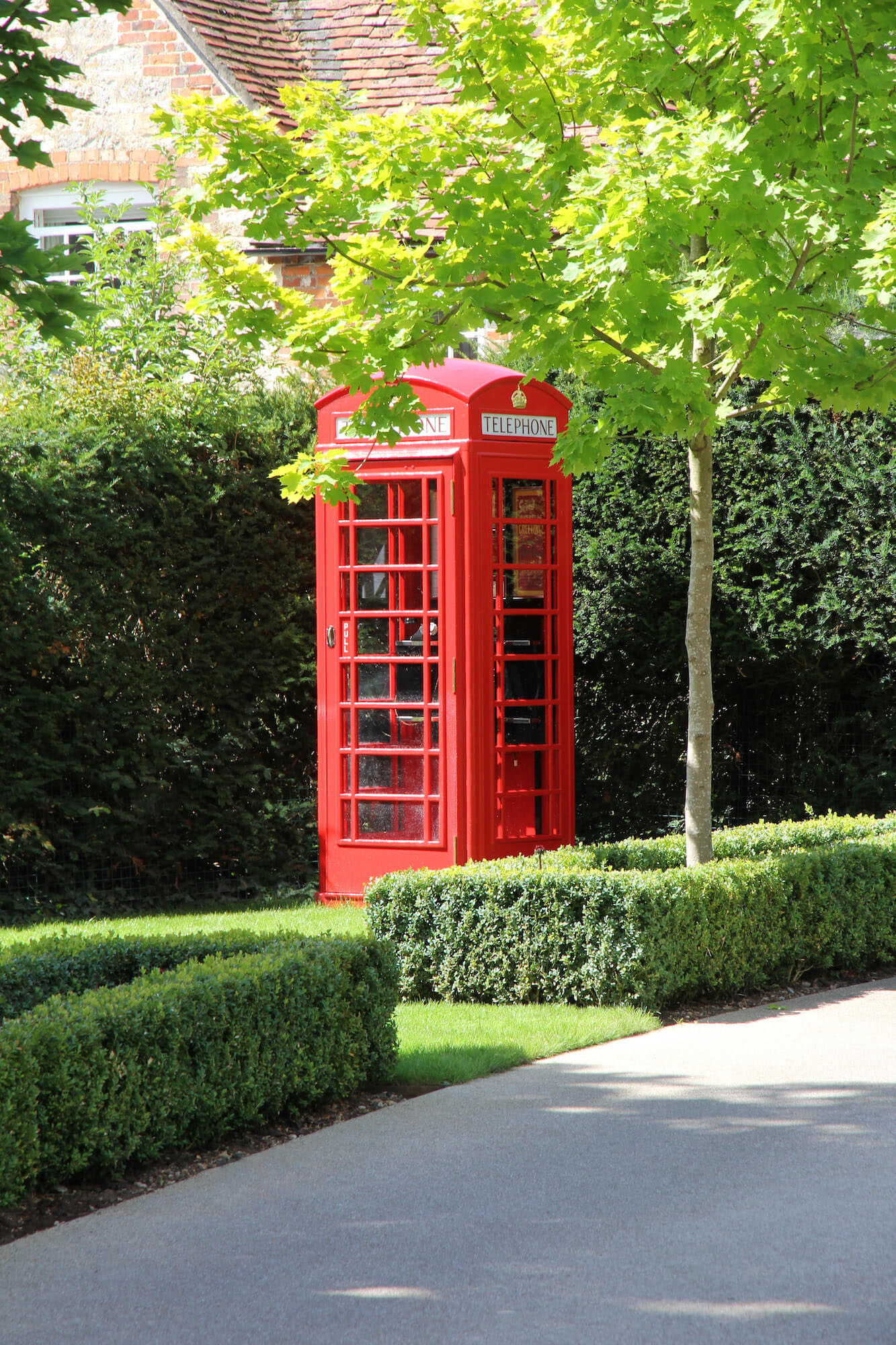 Traditional telephone box in driveway of british garden