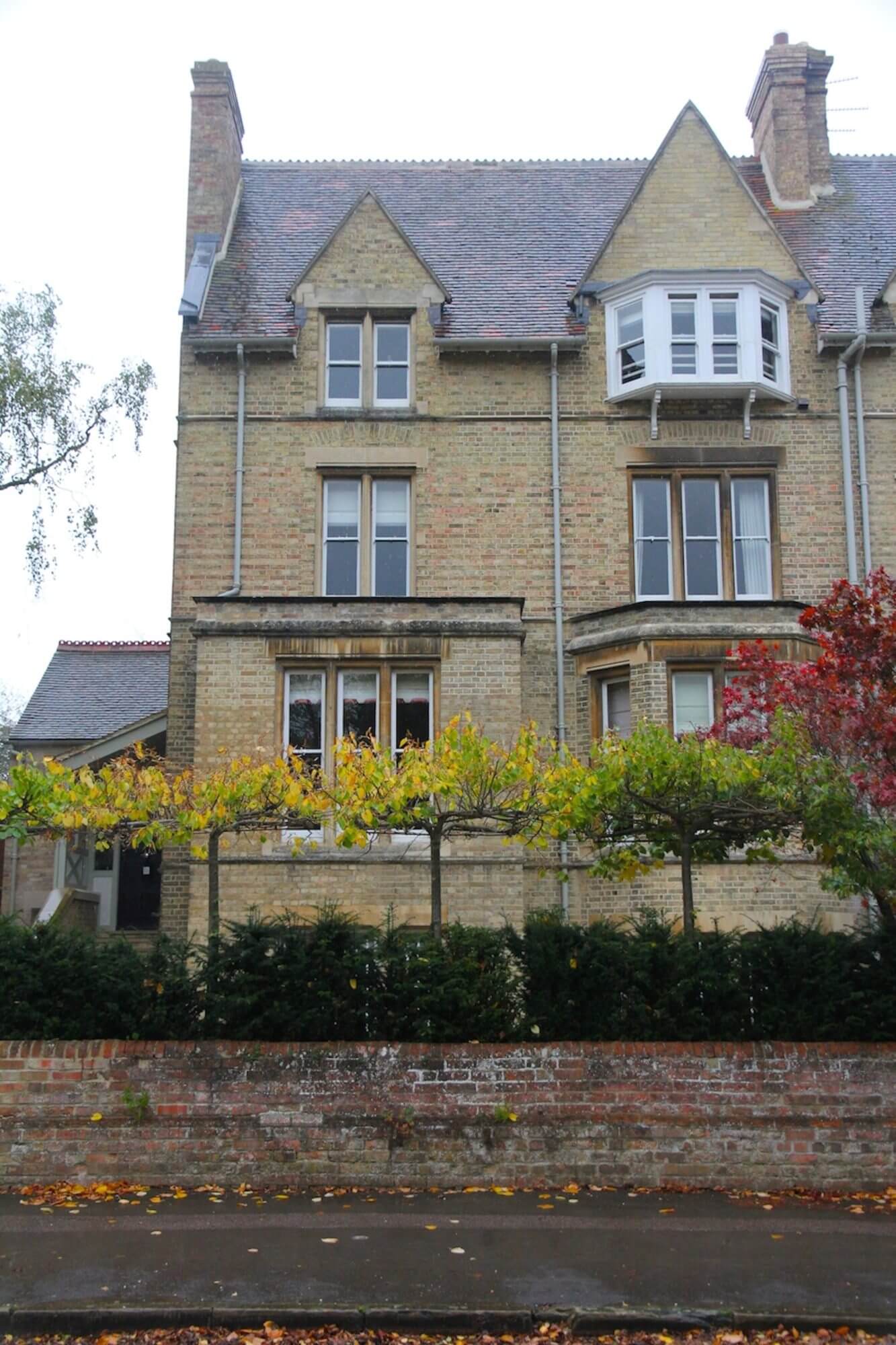 victorian building in oxford with pleached trees and topiary