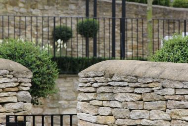 Metal pedestrian gate between two dry stone walls