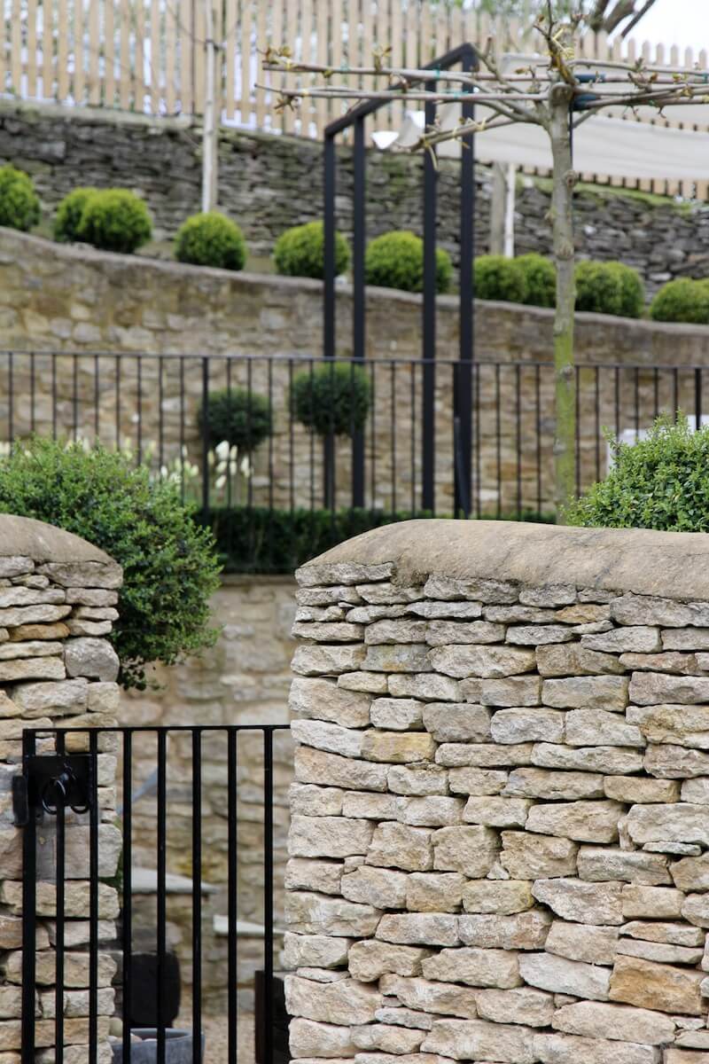 Metal pedestrian gate between two dry stone walls