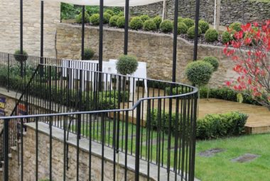 Black metal railing in topiary garden