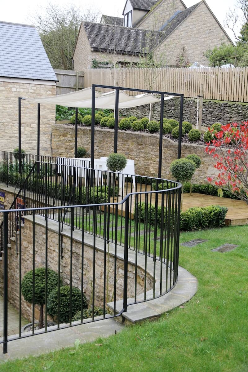 Black metal railing in topiary garden