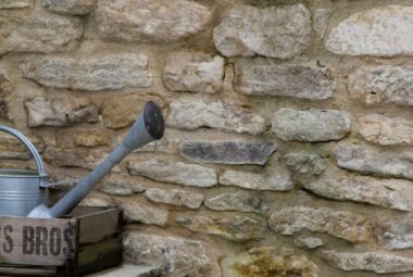 Cotswold stone wall with steps and galvanized watering can