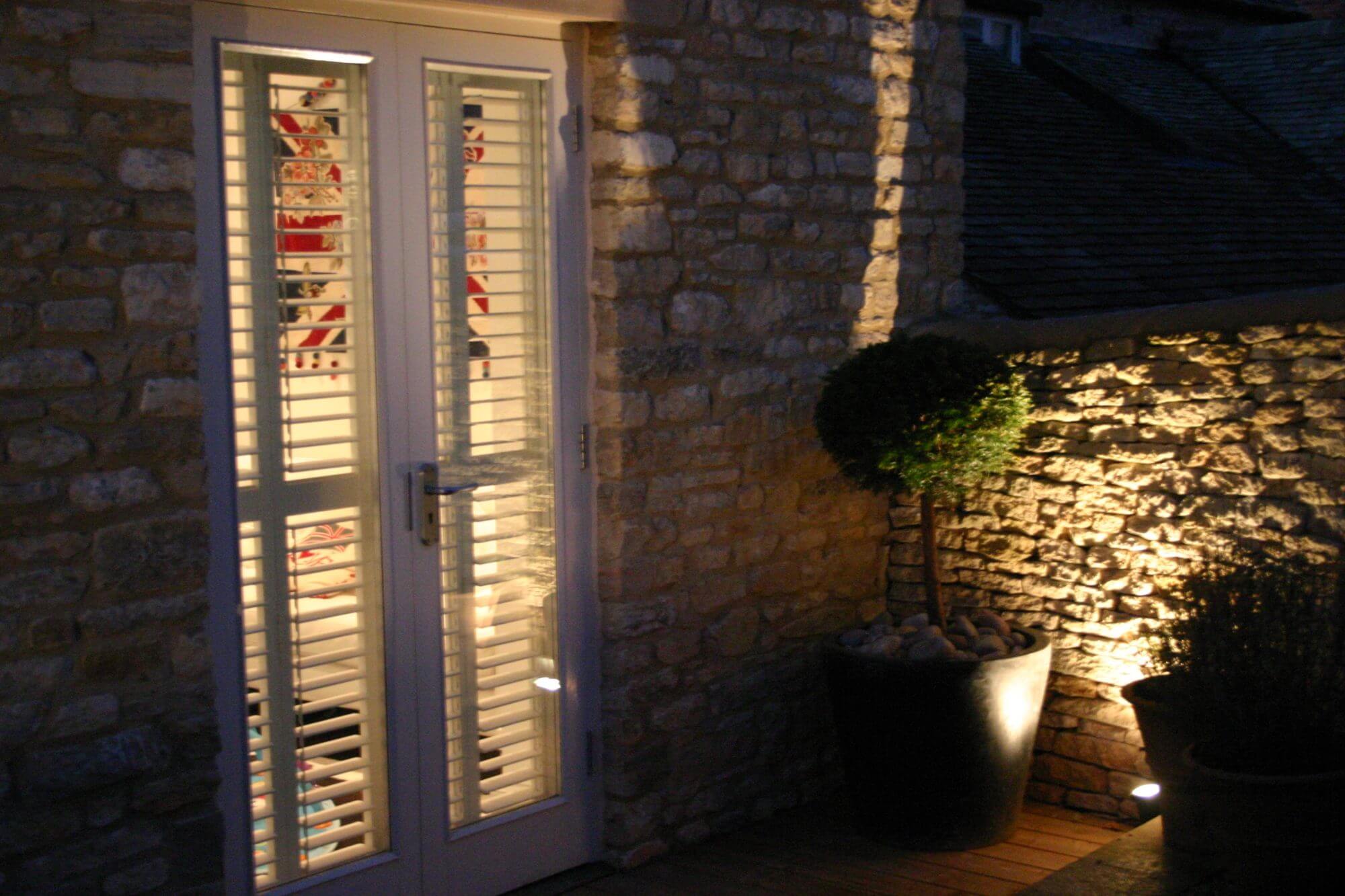 Up lighting on dry stone walls in garden at night