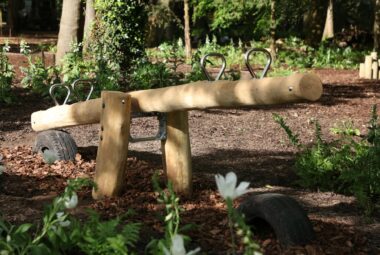 a log garden seesaw in a woodland setting at HWH