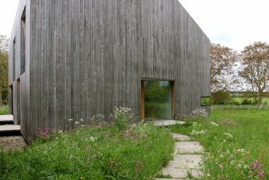 modern barn entrance with wildflower pathway entrance