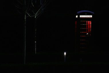 Silhouette of red telephone box light up at night