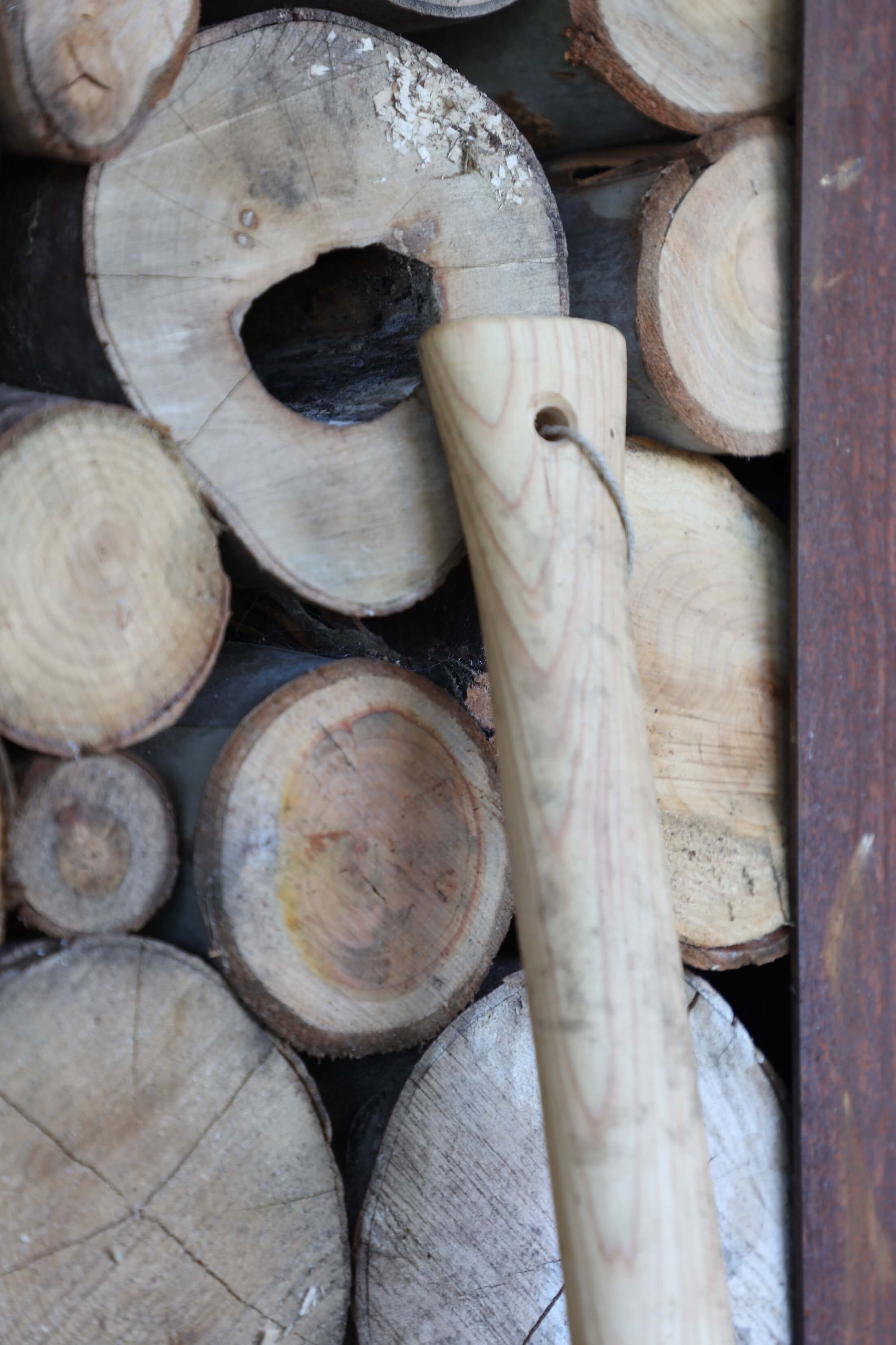 harvest corten log store with axe handle leant up