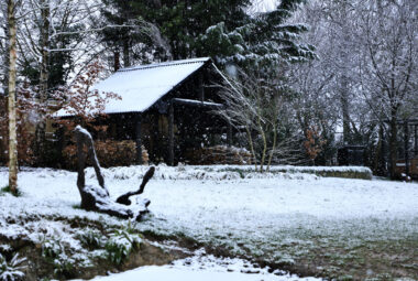 Private garden shack made from wood with snow falling