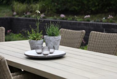 garden wooden table with grey pots on top and herbs