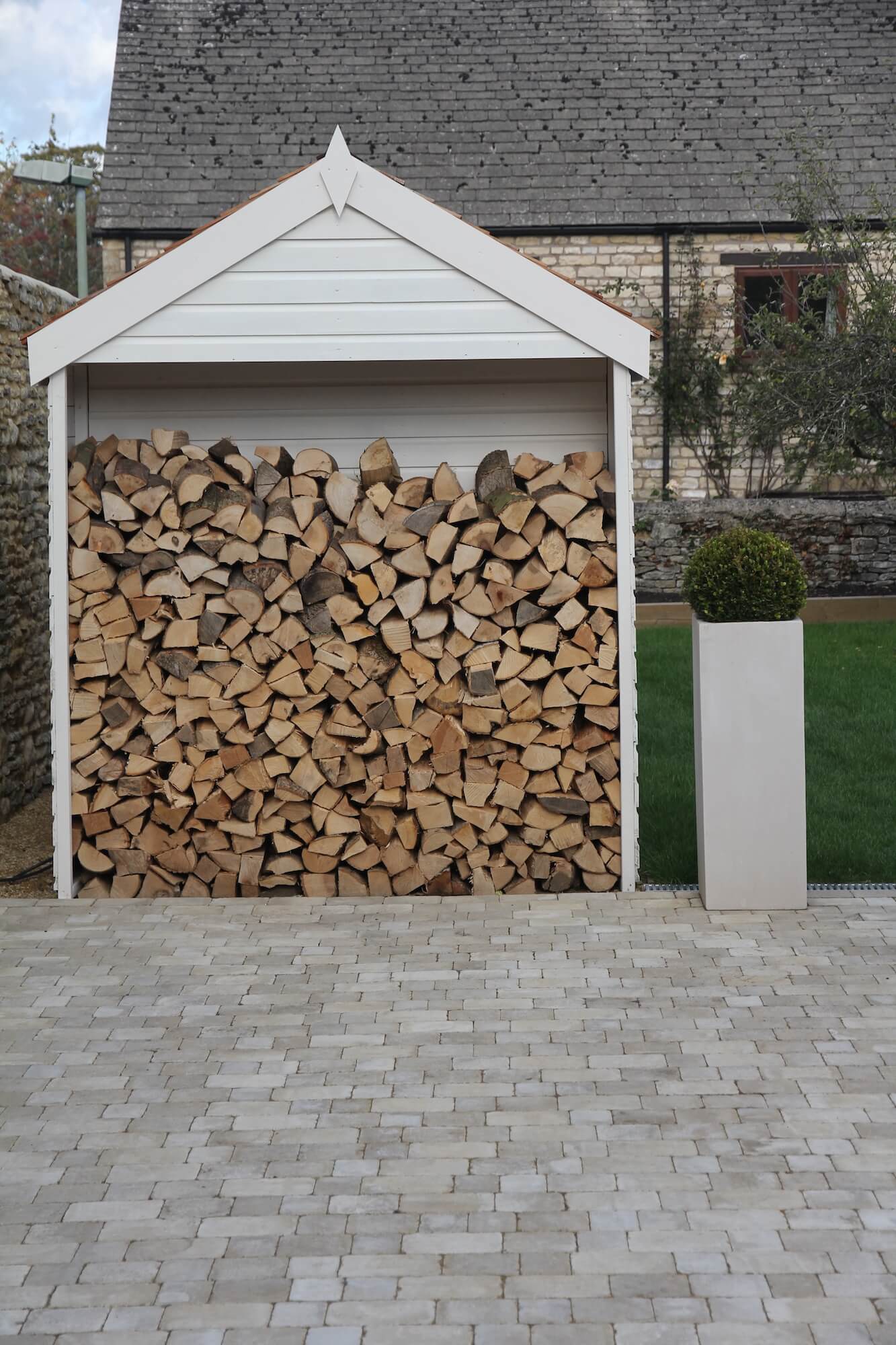 a shed with a built in log store in a twonhouse garden