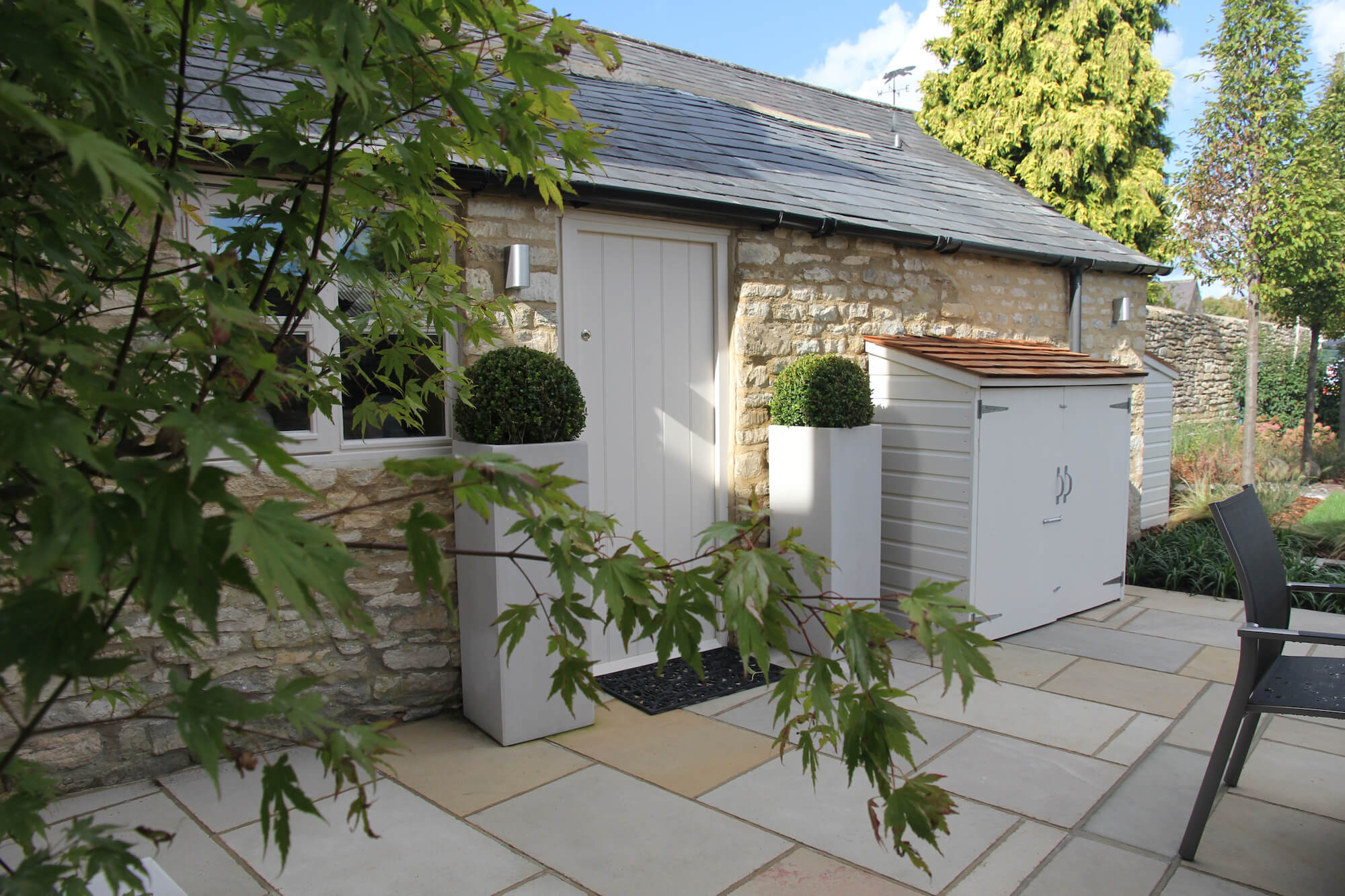 townhouse garden with out buildings and Buxus balls in pots