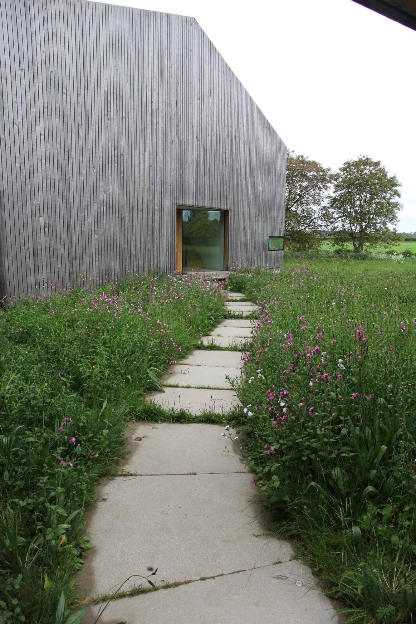 barn in Kingham with wildflower meadow mown paths leading to it