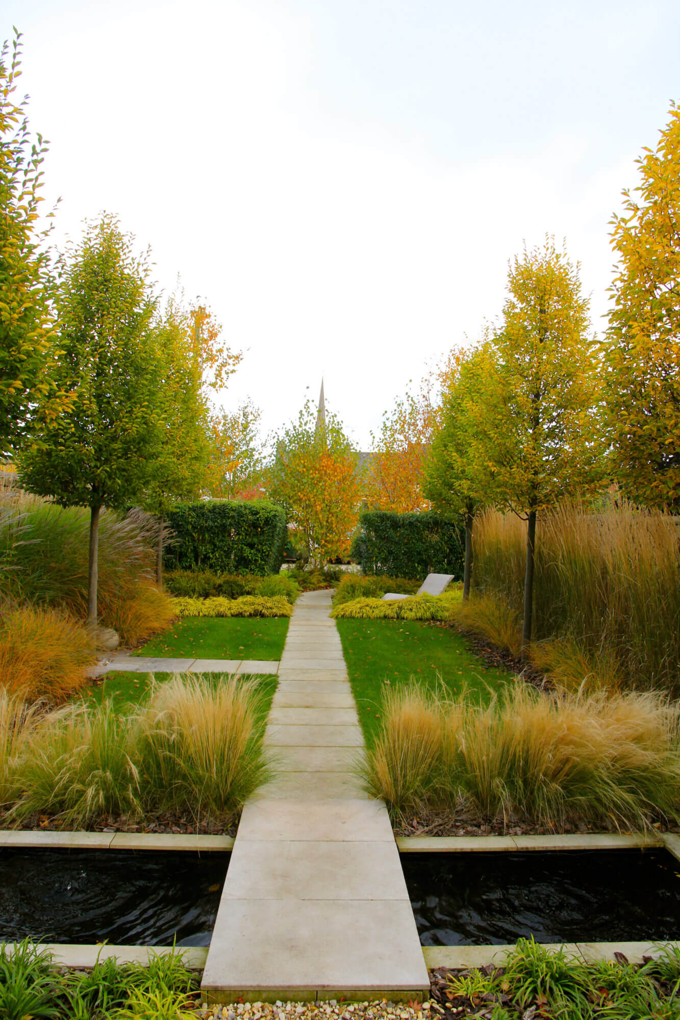 townhouse garden with orange trees lawn path and water pool of black water