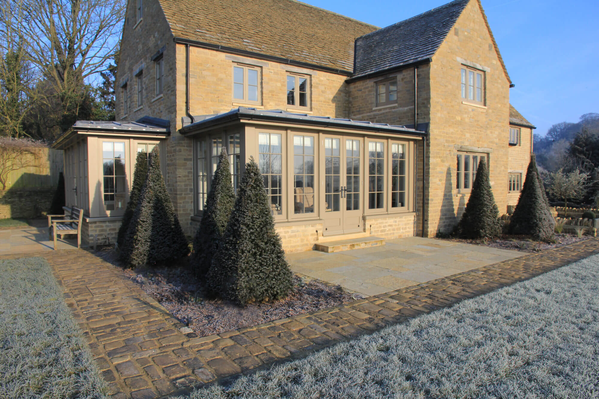 View of The pasture house from the back with triangle topiary trees