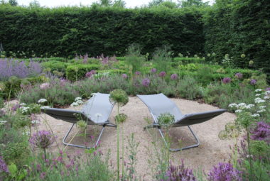 deck chairs in a heavily planted medicinal garden in oxfordshire