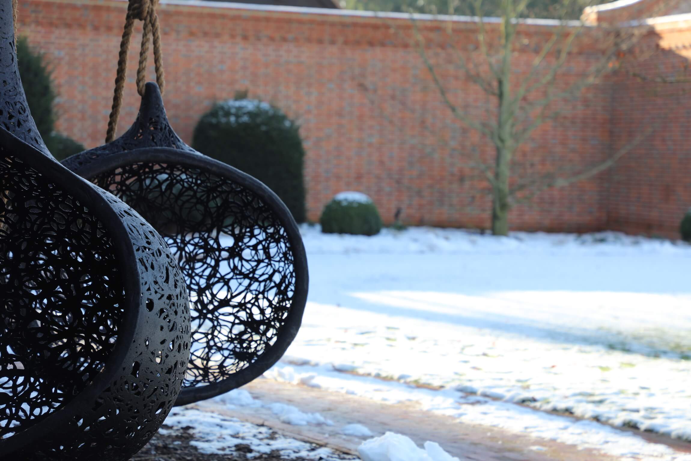 pod nest swings in a garden and melting snow
