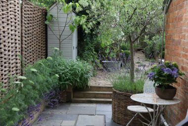 Side alley with red brick house and metal table for two