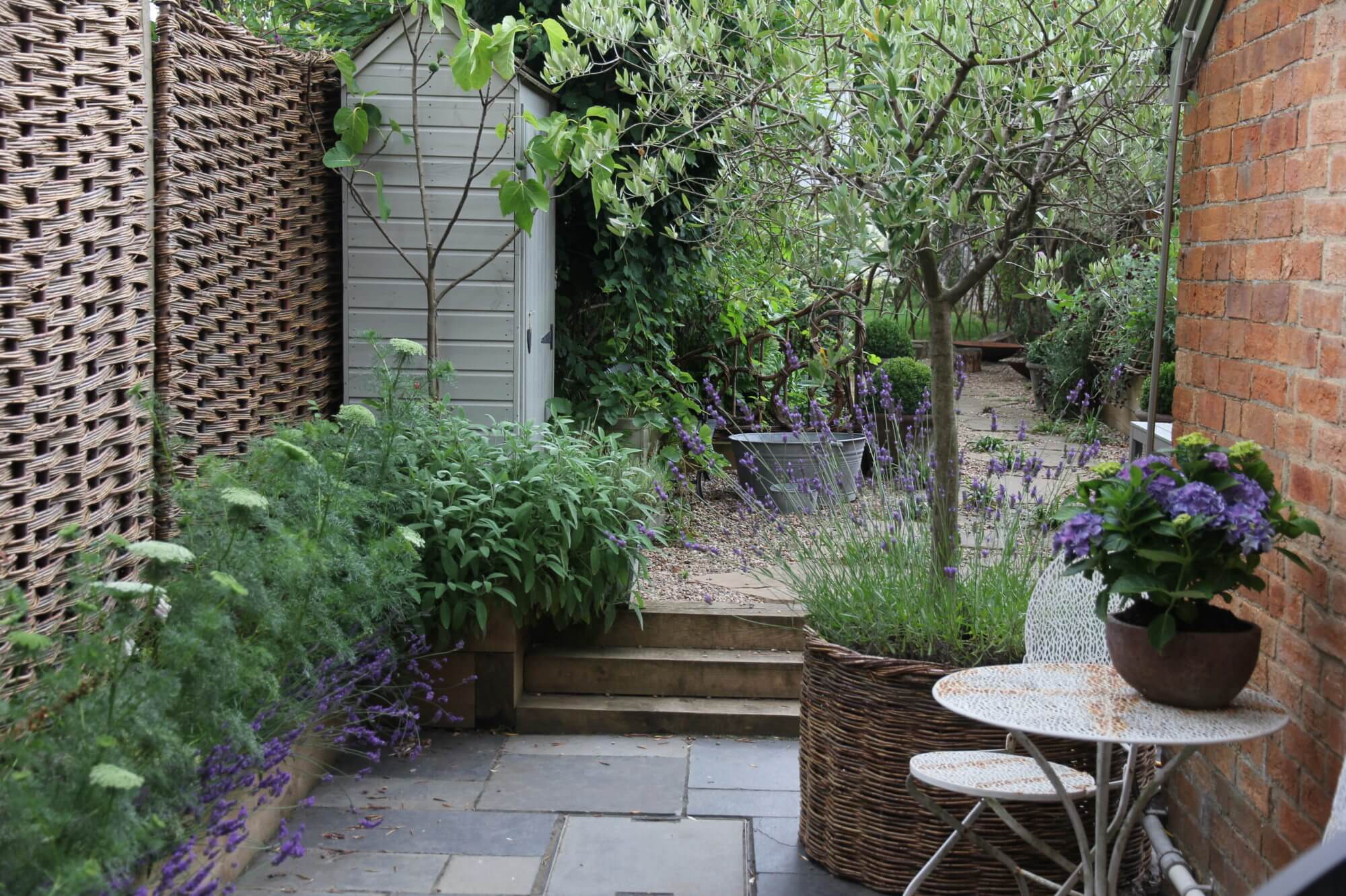 Side alley with red brick house and metal table for two