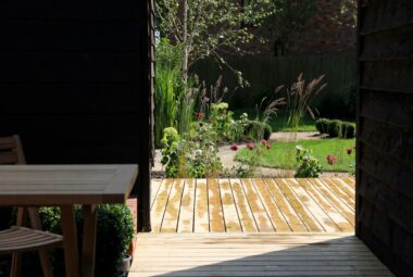 View from indoors of the sunshine on wooden deck view of the garden