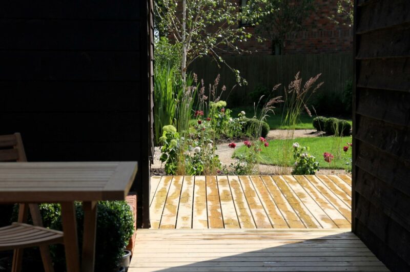 View from indoors of the sunshine on wooden deck view of the garden