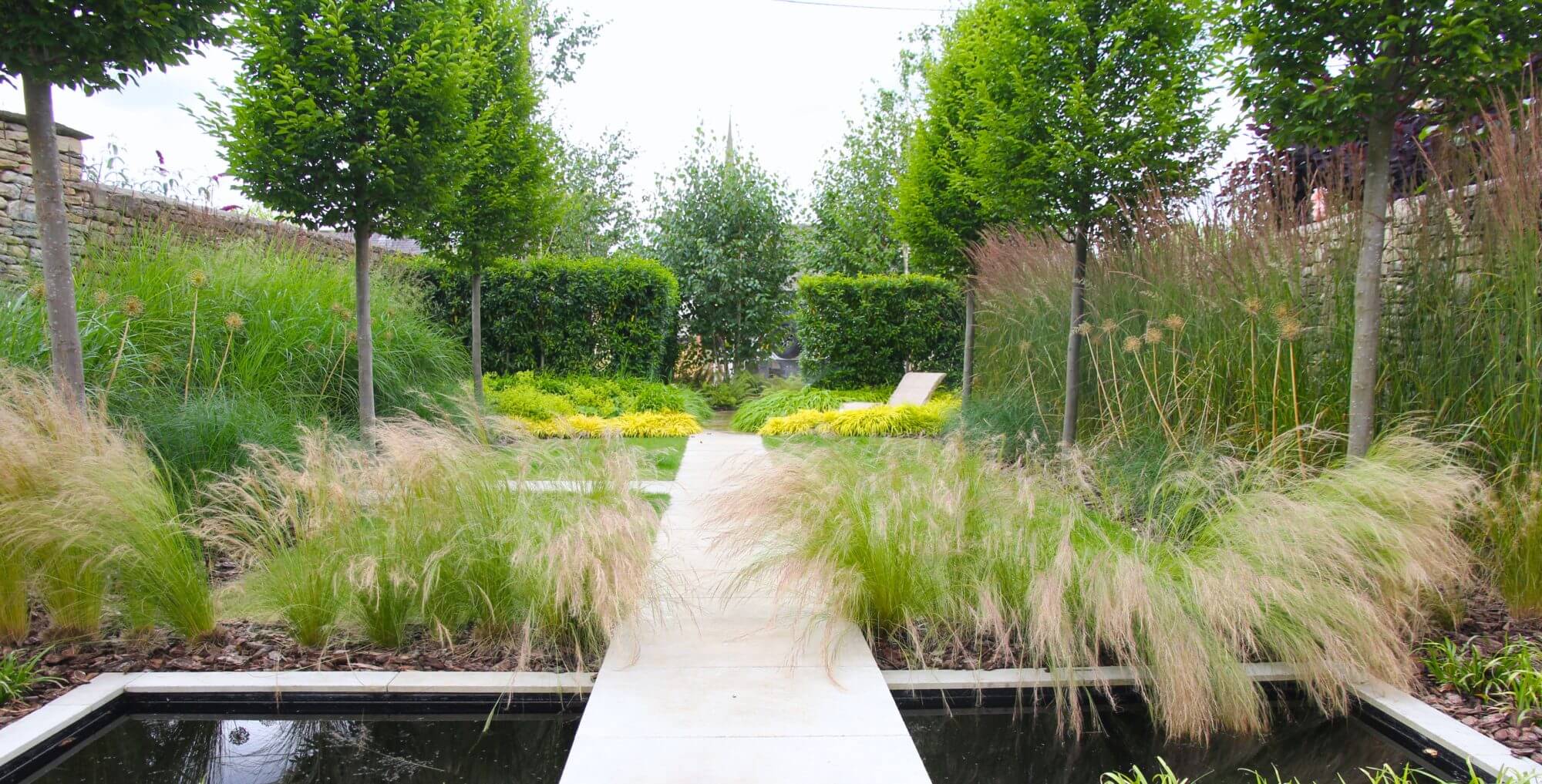 a townhouse garden in Oxford with green planting and a water feature