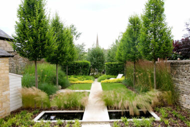 townhouse garden with orange trees lawn path and water pool of black water