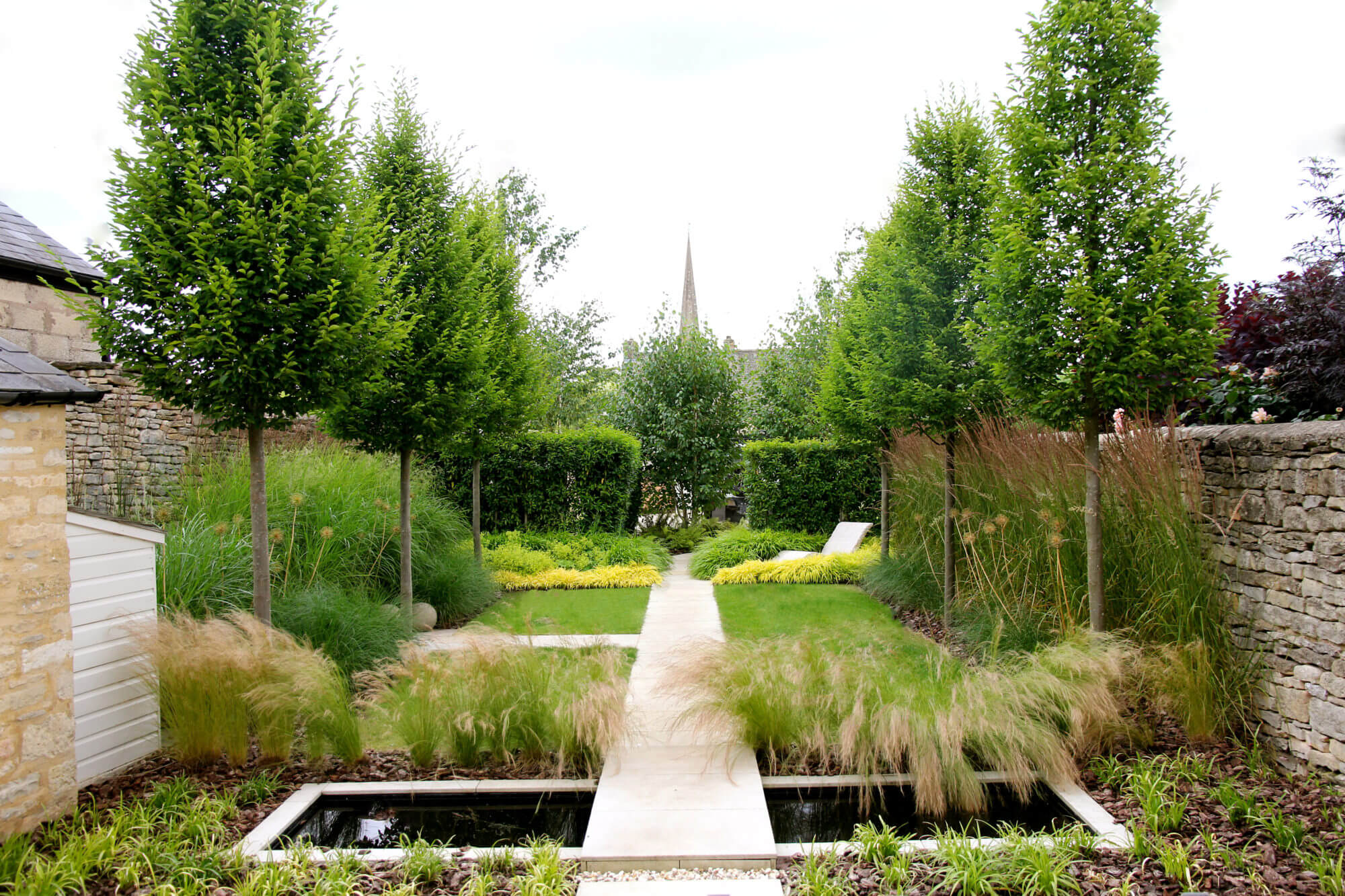 townhouse garden with orange trees lawn path and water pool of black water