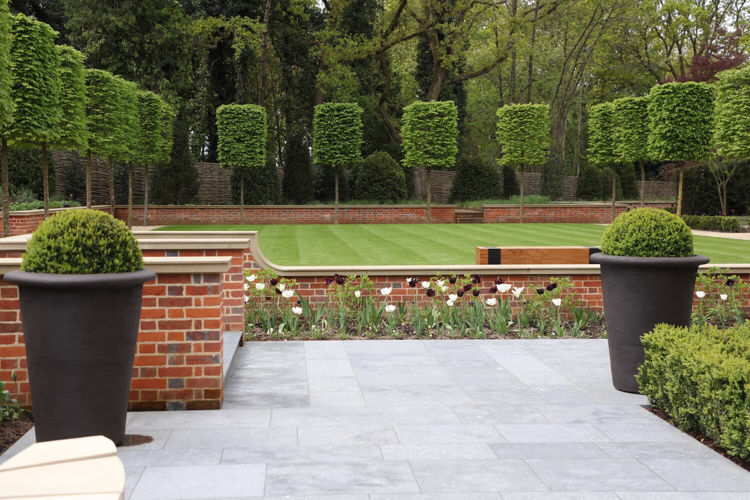 a bowling green garden design with green pleached trees at Harpsden Wood House