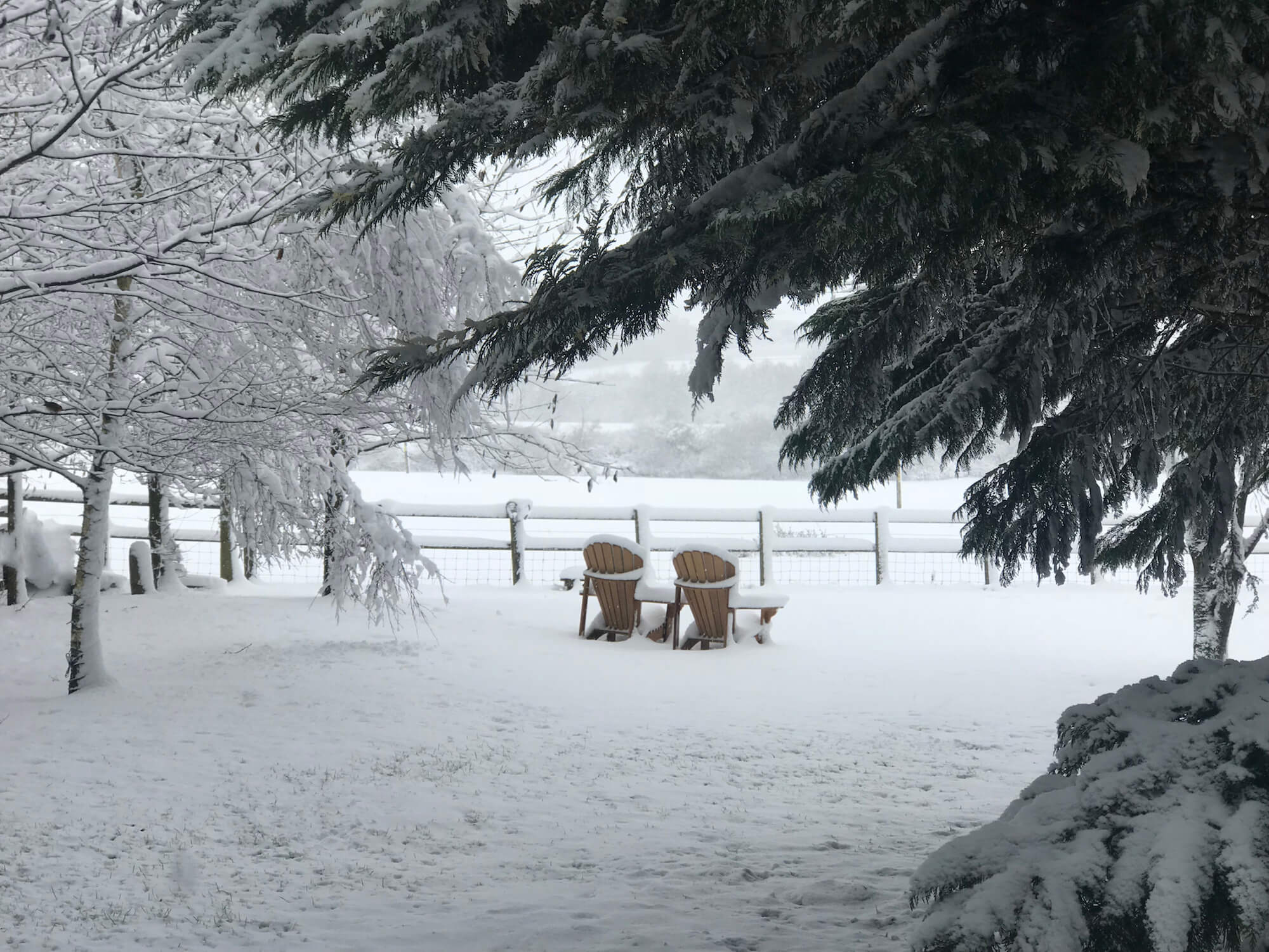 snow covered cotswold landscape with Adirondack chairs